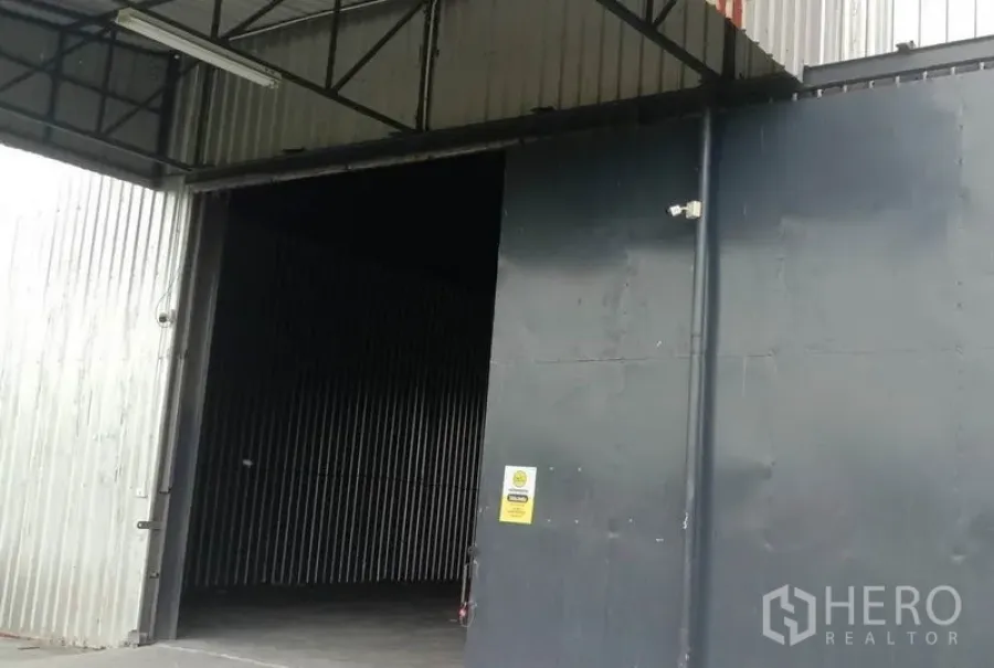 Warehouse for rent in Chon Buri - Steel-clad warehouse in Phan Thong with a large sliding steel door, high truss roof and concrete forecourt.