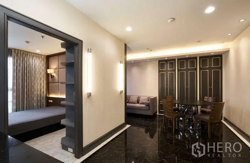 Condominium for sale in Ratchathewi, Bangkok - View from bedroom to living area with dining set and full-height storage in a Ratchathewi condo.