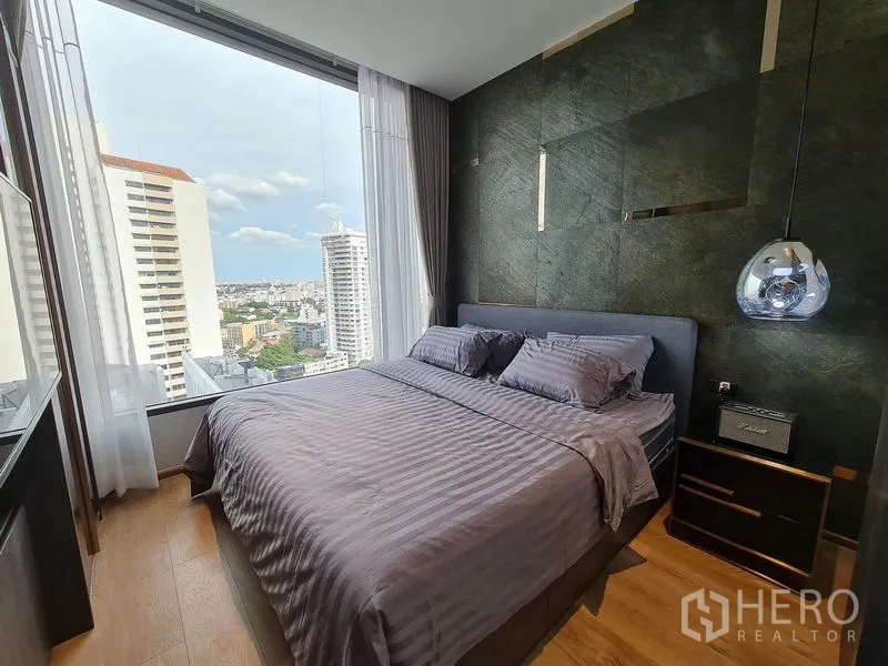 Condominium for rent - Second bedroom with large window, dark accent wall, pendant light and skyline view.