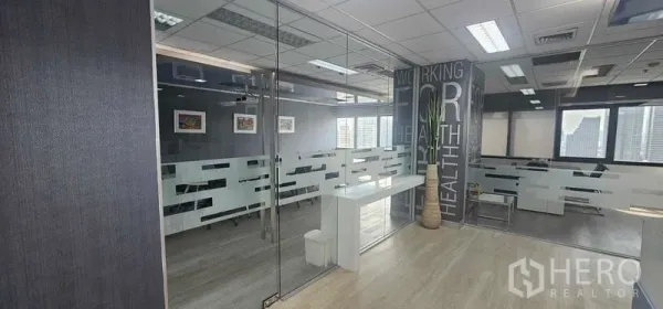 สำนักงาน ให้เช่าในBang Rak, Bangkok - โซนสำนักงานแบบเปิดโล่ง พาร์ทิชันกระจก กราฟิกผนัง กระถางต้นไม้ และหน้าต่างบานใหญ่