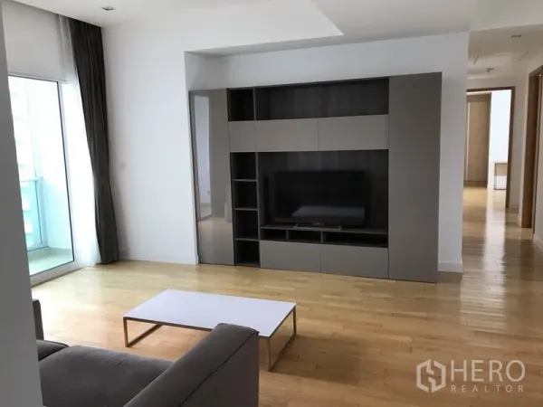 คอนโด ให้เช่าในKhlong Toei, Bangkok - ห้องนั่งเล่นสว่างพร้อมชั้นวางทีวีบิลต์อิน พื้นไม้ และทางออกสู่ระเบียง