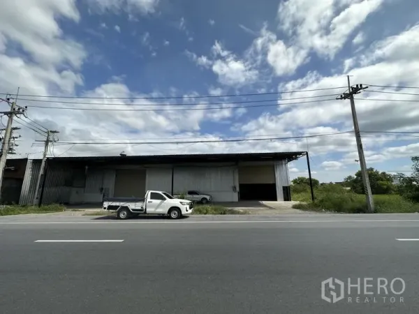 货栈 出租在Khlong Luang, Pathum Thani - 仓库正立面全景，可见多扇卷帘门与连接主干道的车道。