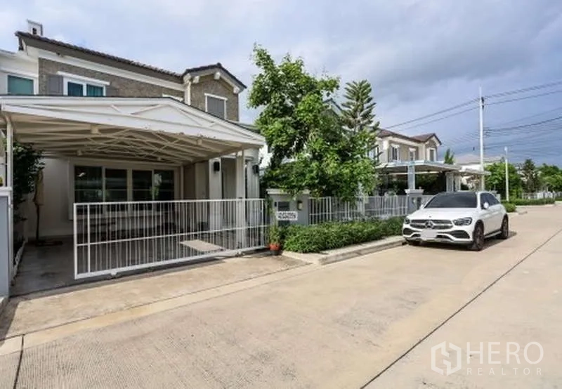 Detached House for rent or sale in Prawet, Bangkok - Quiet community street view of the gated house with covered carport.