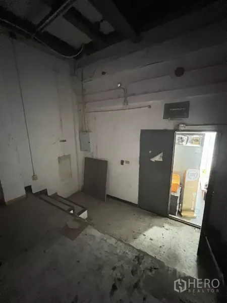 零售空间 出租在Watthana, Bangkok - 后勤区域，管线到位，侧门通向储物间。