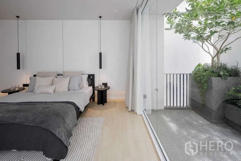 Home Office for rent in Bang Phli, Samut Prakan - Bedroom with glass wall opening to a planted terrace beside the bed.