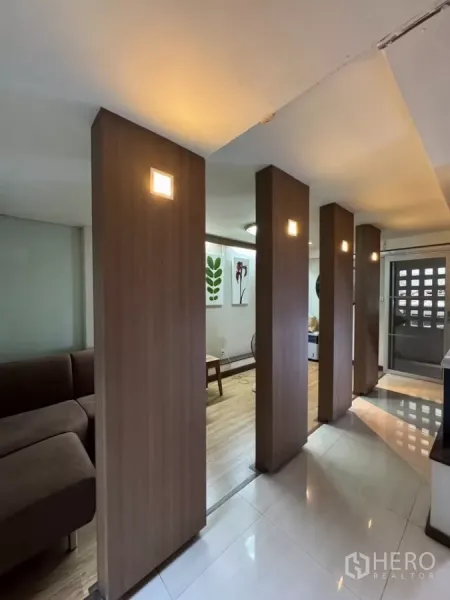 店屋 出租在Bang Rak, Bangkok - 走廊以竖向木柱和灯光分隔，通向起居区。