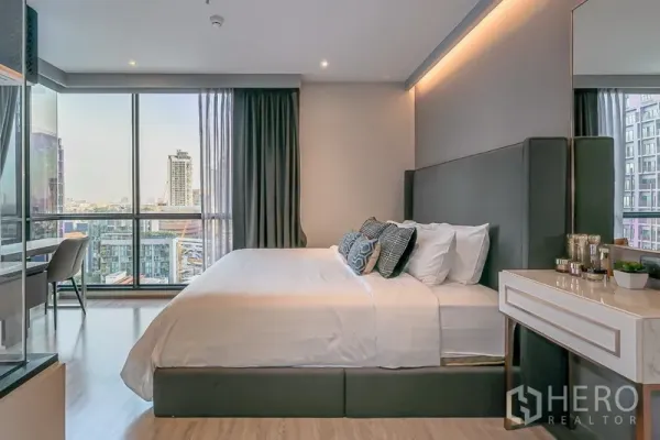 Condominium for rent in Watthana, Bangkok - Master bedroom side view with king bed, study desk by window, and skyline outlook.