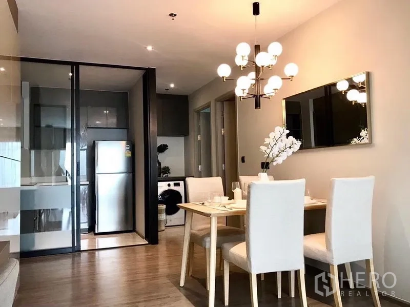 คอนโด ให้เช่าในWatthana, Bangkok - โต๊ะทานอาหารสี่ที่นั่งข้างครัวกั้นกระจก มีตู้เย็นและเครื่องซักผ้า