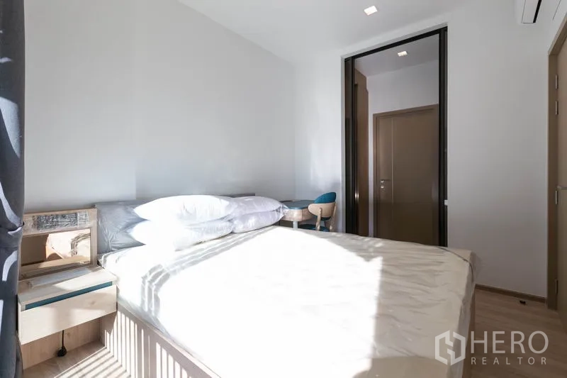 คอนโด ให้เช่าในWatthana, Bangkok - ห้องนอนรับแสงธรรมชาติ เตียง โต๊ะหัวเตียง และประตูบานเลื่อนสู่ห้องนั่งเล่น