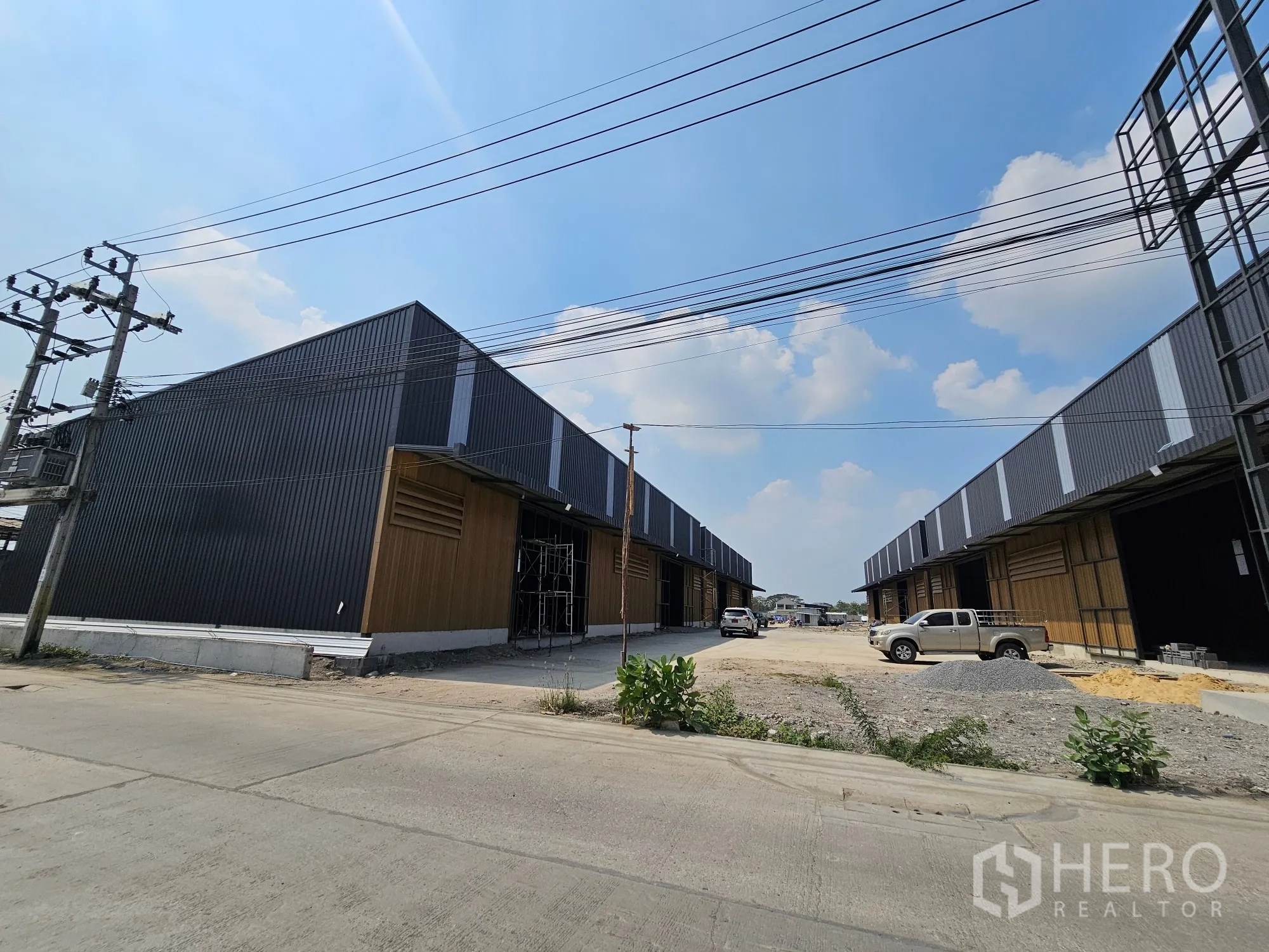 仓库 for rent in Bang Khen, Bangkok - 新建仓库成排分布，中央为宽阔车道并有架空电缆。