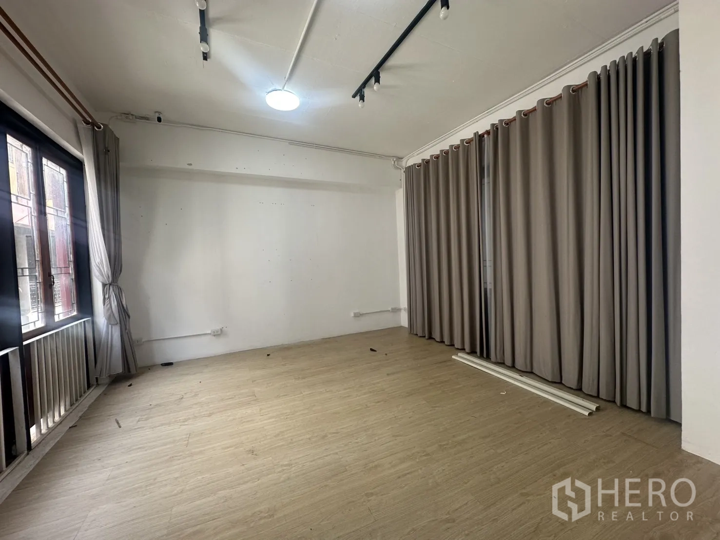 สำนักงานที่บ้าน ให้เช่าในPathum Wan, Bangkok - ห้องเอนกประสงค์พื้นลามิเนตลายไม้ ผ้าม่านเต็มผนังและหน้าต่างระเบียง