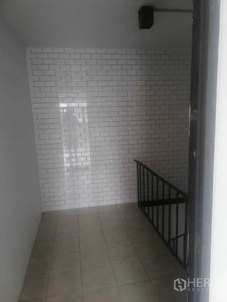 Shophouse for rent in Khlong Toei, Bangkok - Stairwell nook with white subway tile feature wall and metal railing.
