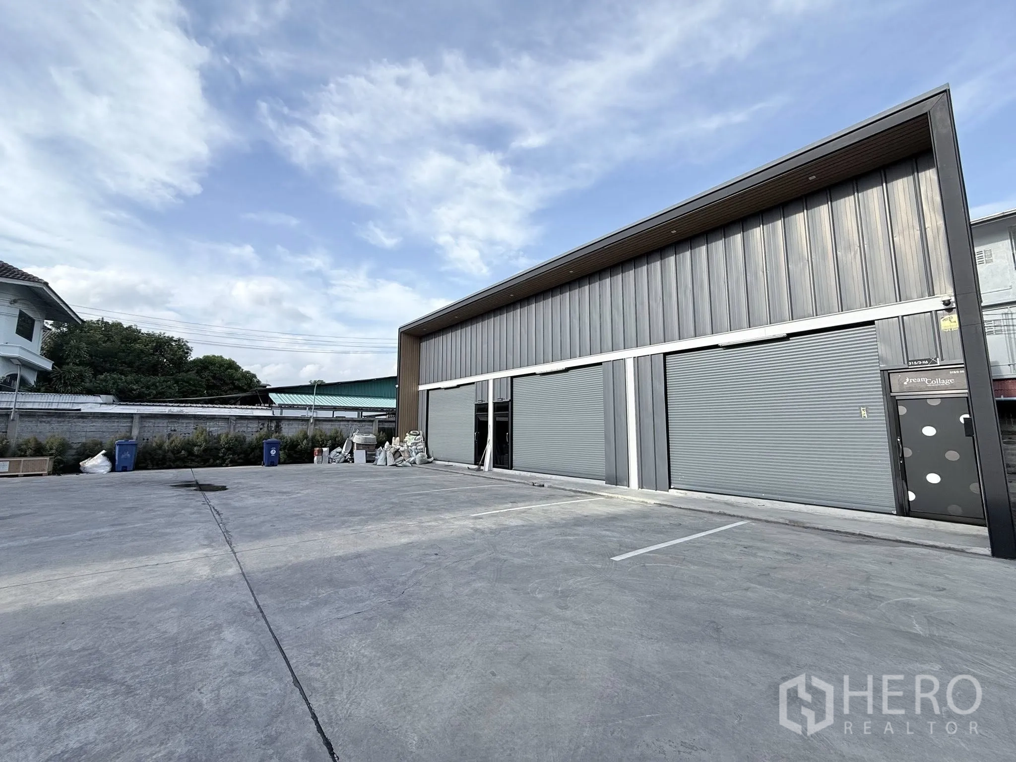 คลังสินค้า ให้เช่าในSuan Luang, Bangkok - ด้านหน้าโกดังสมัยใหม่ มีประตูม้วน 3 บานและลานคอนกว้างสำหรับจอดรถ ในเขตสวนหลวง กรุงเทพฯ