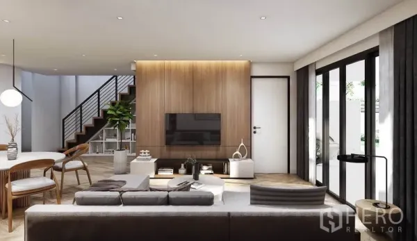 Detached House for rent in Watthana, Bangkok - Bright living room featuring a wood accent wall, large sliding glass doors, and a staircase.