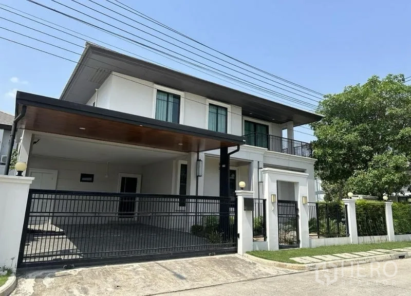 Detached House for sale in Prawet, Bangkok - Modern two-storey detached house with gated entrance and covered carport.