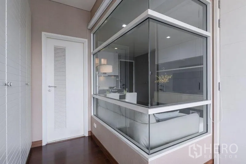คอนโด ให้เช่าหรือขายในWatthana, Bangkok - โถงภายในห้องพร้อมผนังกระจกบานใหญ่และประตูสีขาวข้างห้องนอน