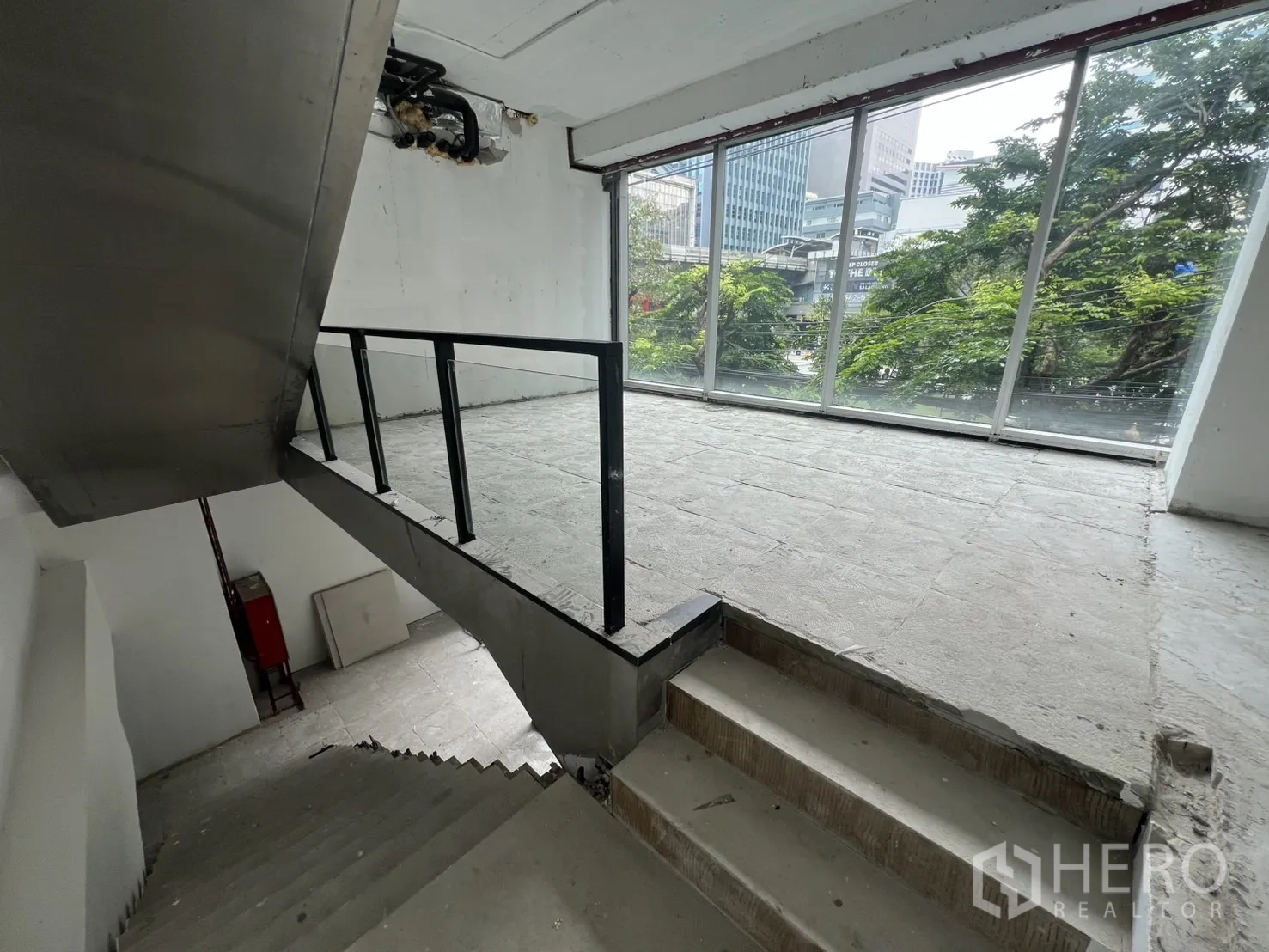 พื้นที่ขายปลีก ให้เช่าในBang Rak, Bangkok - ชานพักบันไดเชื่อมเมซซานีน พร้อมกระจกเต็มความสูงและวิวเมือง