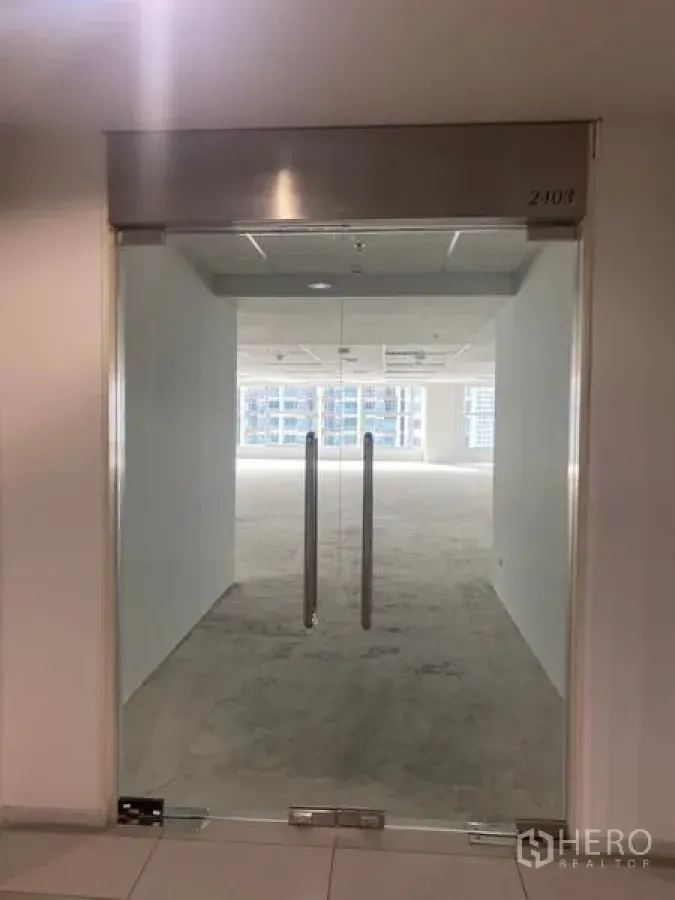 Office Space for rent in Bang Rak, Bangkok - Glass double doors leading into an unfurnished open‑plan office with white walls and ceiling lights in Silom, Bangkok.