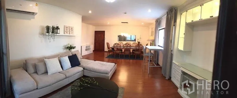 คอนโด ให้เช่าหรือขายในDin Daeng, Bangkok - ภาพมุมกว้างของคอนโดแบบโอเพนสเปซ แสดงโซนนั่งเล่น มุมทำงาน และพื้นที่รับประทานอาหารบนพื้นไม้.