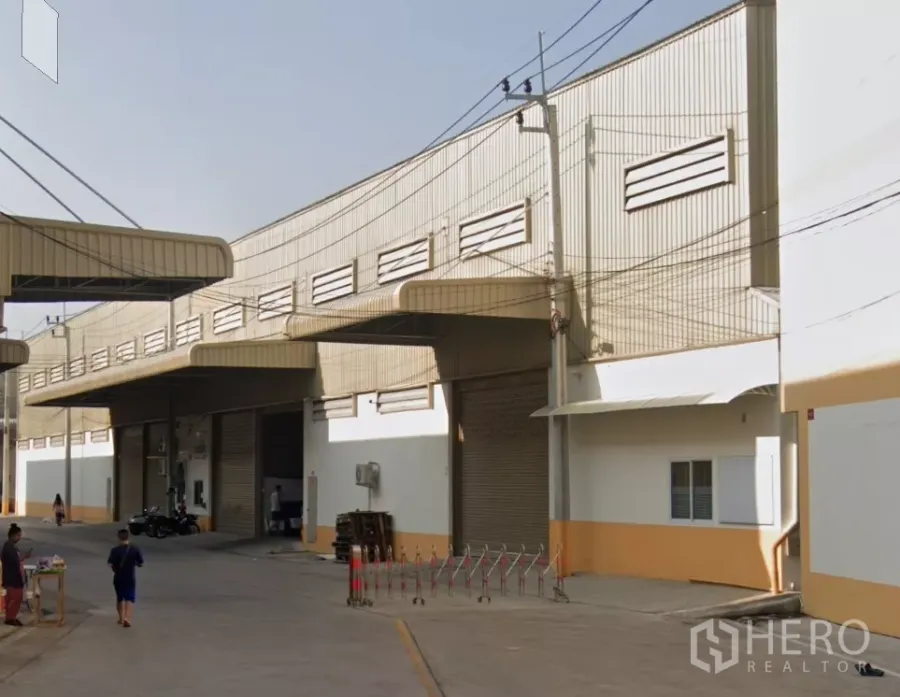 货栈 出租在Bang Khun Thian, Bangkok - 工业园区外观：金属板仓库排屋，多个卷帘门，带遮雨装卸区与宽阔车道，位于曼谷邦坤天。