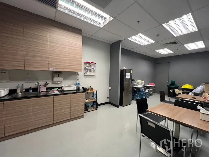 办公空间 出租在Huai Khwang, Bangkok - 员工茶水间，木质橱柜、水槽、冰箱与用餐桌。