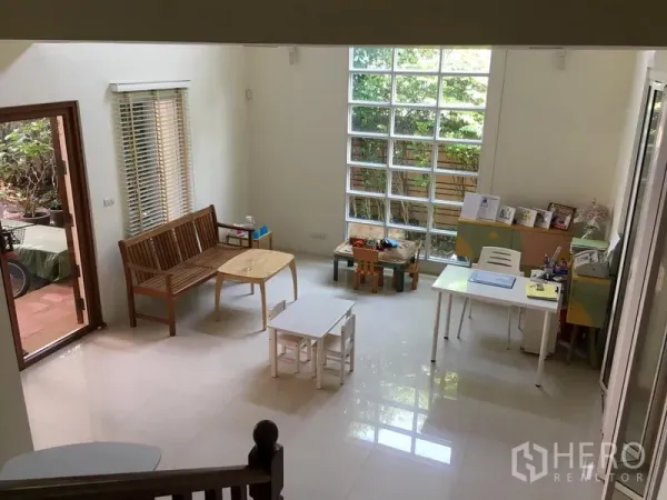 ทาวน์เฮาส์ ขายในHuai Khwang, Bangkok - พื้นที่นั่งเล่นชั้นล่างสว่าง พื้นกระเบื้องเงา หน้าต่างบล็อกแก้ว และทางออกสู่สวน