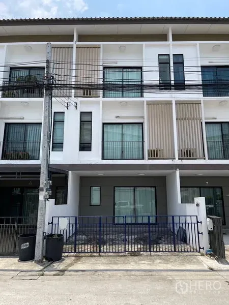 Townhouse for rent in Bang Kapi, Bangkok - Three-storey modern townhouse facade with balconies and gated front area.