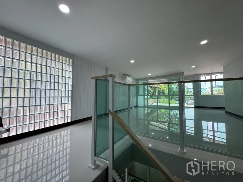 Townhouse for sale in Bueng Kum, Bangkok - Upstairs corridor with glass block wall and glass-railed landing.
