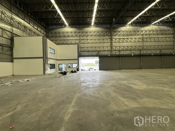 Warehouse for rent in Lat Krabang, Bangkok - High-ceiling warehouse interior with roller doors and an integrated office block.