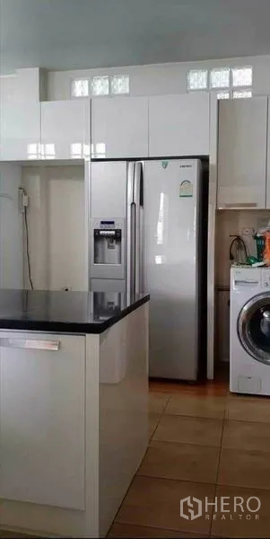 บ้าน ขายในPrawet, Bangkok - ครัวบิวท์อินสีขาว เคาน์เตอร์ท็อปสีดำ พร้อมตู้เย็นสแตนเลสและเครื่องซักผ้า