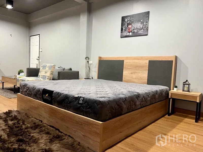 Shophouse for sale in Bang Kho Laem, Bangkok - Queen bed with wood frame and matching bedside tables on timber flooring.