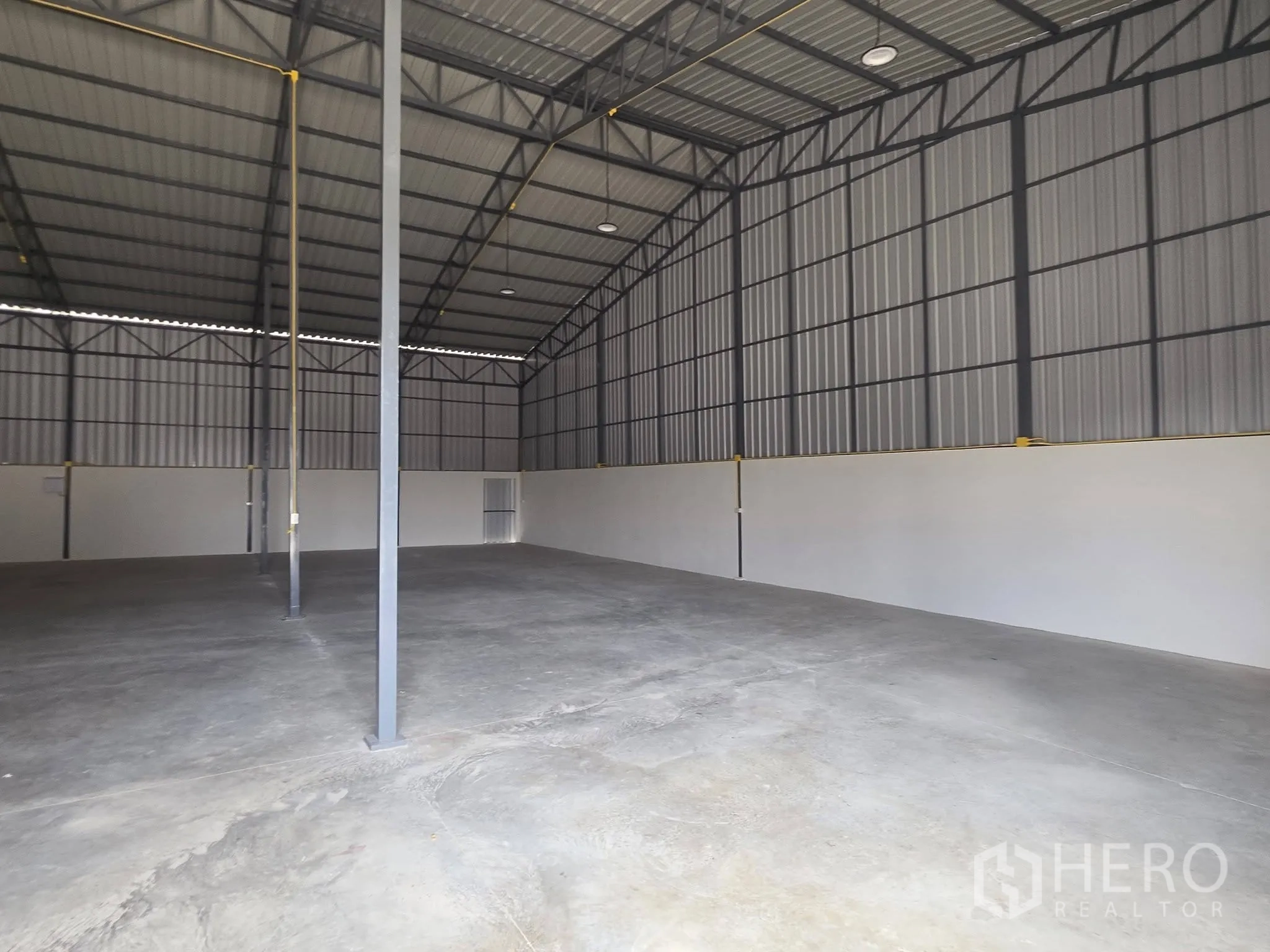 โกดัง for rent in Mueang Samut Prakan, Samut Prakan - ภายในโกดังแสดงโครงหลังคาเหล็ก เพดานสูง เสาค้ำ และพื้นคอนกรีตเรียบ