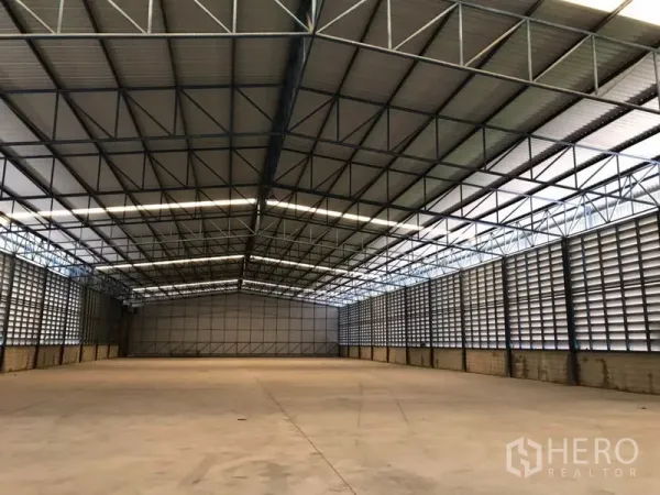 货栈 出租在Khlong Sam Wa, Bangkok - 近距离展示金属桁架高顶与天窗带，覆盖宽阔的空仓区域。