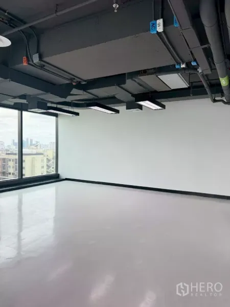 办公空间 出租在Din Daeng, Bangkok - 转角办公区，大幅玻璃与亮面地坪，自然采光充足。