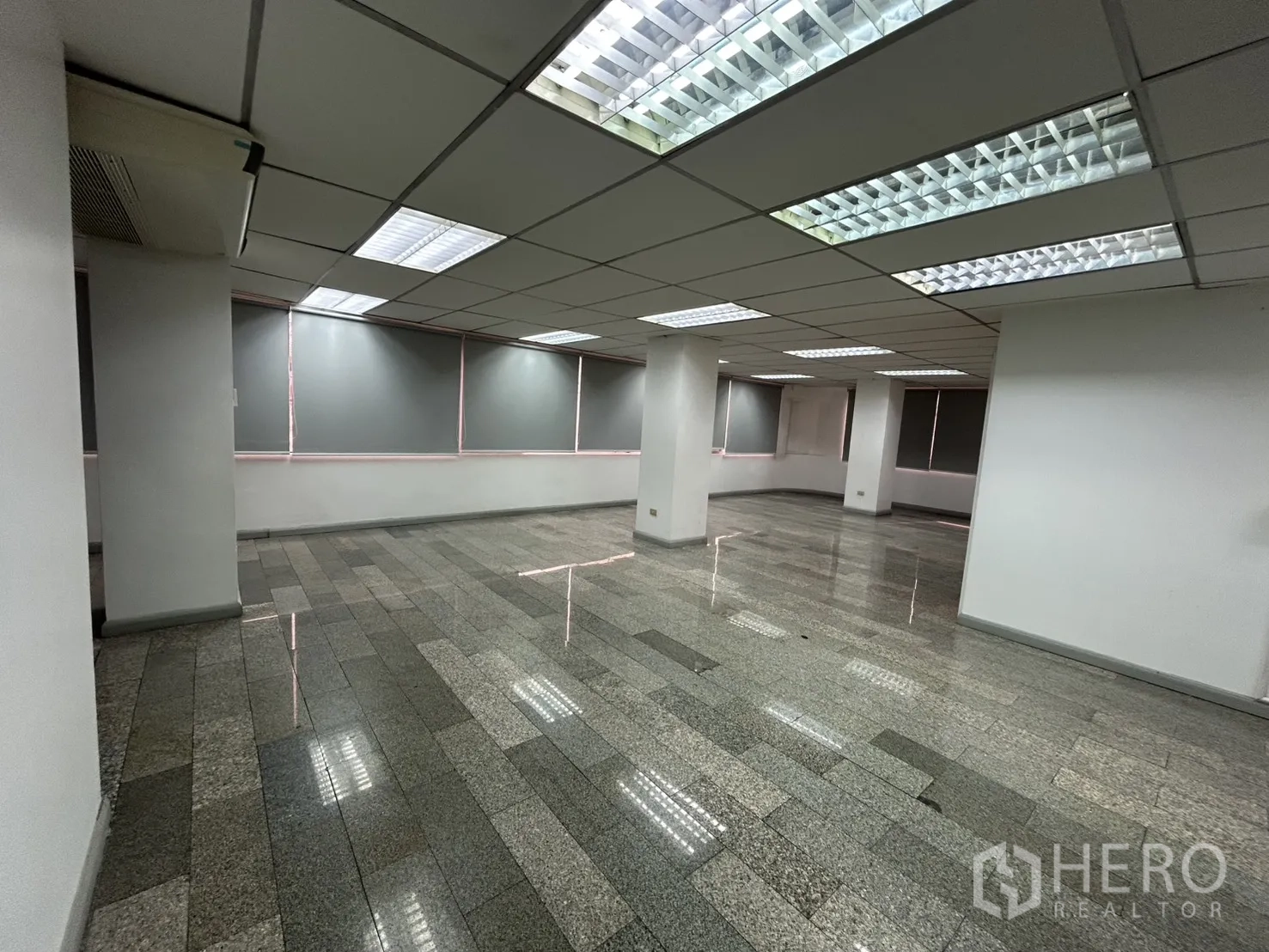 ออฟฟิศ for rent in Khlong Toei, Bangkok - ชั้นสำนักงานกว้าง มีเสา พื้นกระเบื้อง ม่านม้วน และไฟสว่างทั่วถึง