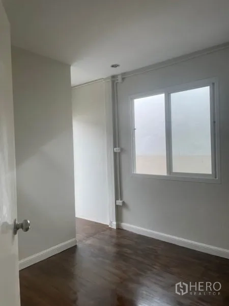 บ้าน ให้เช่าในHuai Khwang, Bangkok - ห้องนอนขนาดกะทัดรัด พื้นไม้ ผนังโทนสว่าง และหน้าต่างรับแสงธรรมชาติ.