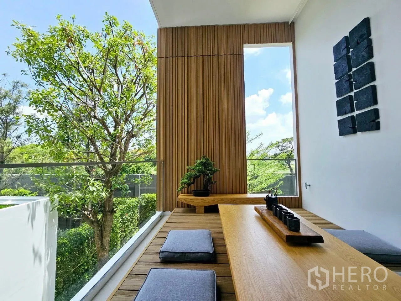 บ้าน ให้เช่าในSaphan Sung, Bangkok - มุมจิบน้ำชาบนระเบียง โต๊ะเตี้ย เบาะนั่ง และบอนไซหน้าผนังไม้