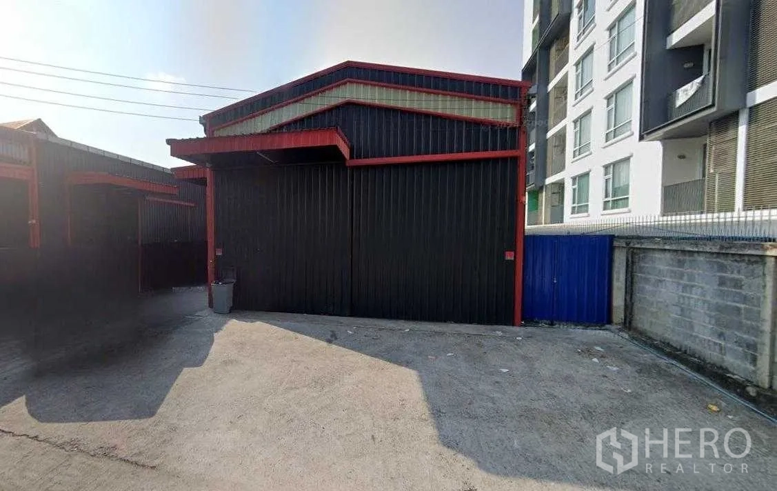 Warehouse for rent in Chatuchak, Bangkok - Street-side facade of the steel-clad warehouse with gated entry and loading apron.