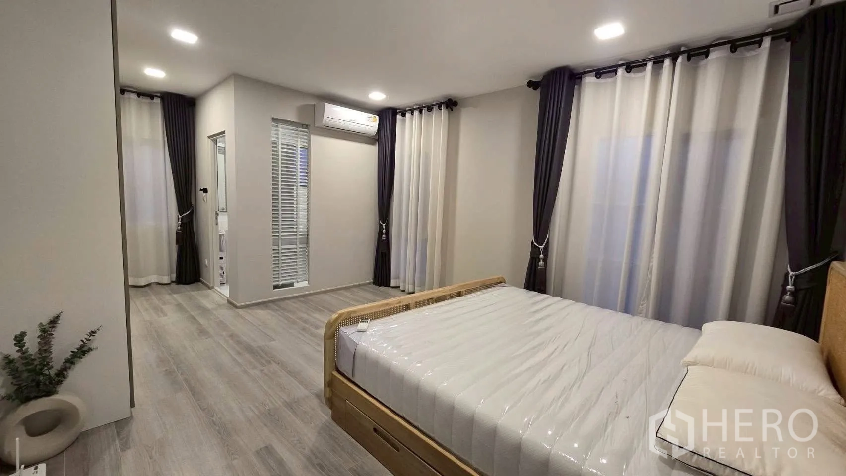 Semi-detached House for rent in Prawet, Bangkok - Spacious bedroom with bed, multiple windows and a doorway to an adjoining area.