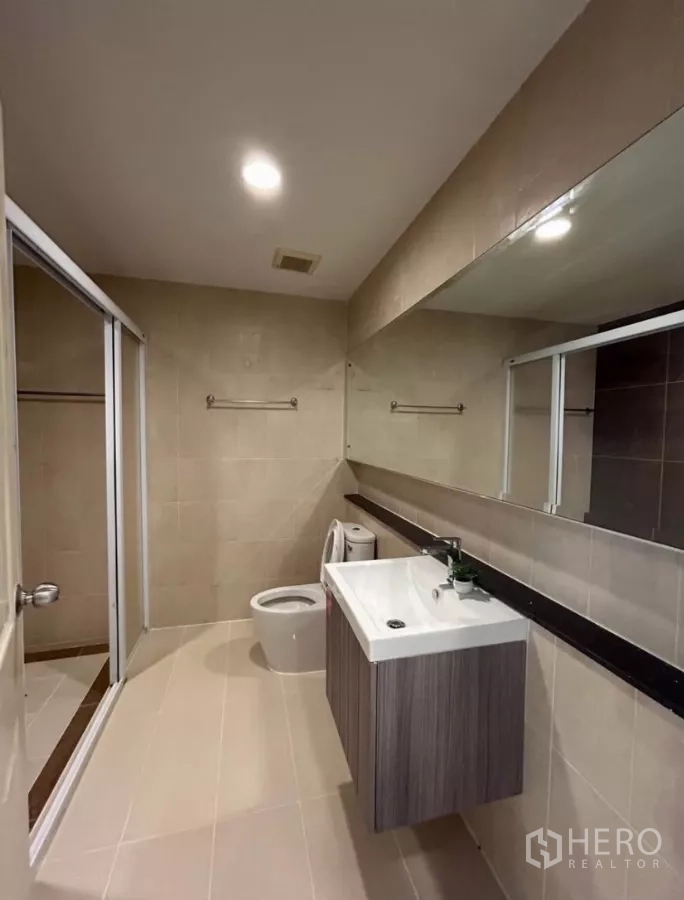 Townhouse for rent in Wang Thonglang, Bangkok - Main bathroom with long vanity, toilet and glass shower enclosure