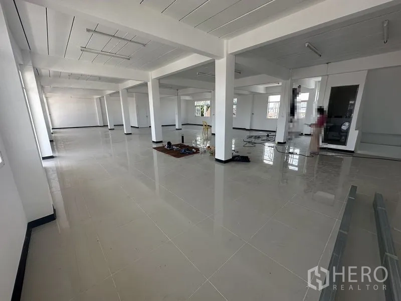 Home Office for rent in Phra Khanong, Bangkok - Open-plan floor during fit-out with scattered tools and wide perimeter windows.