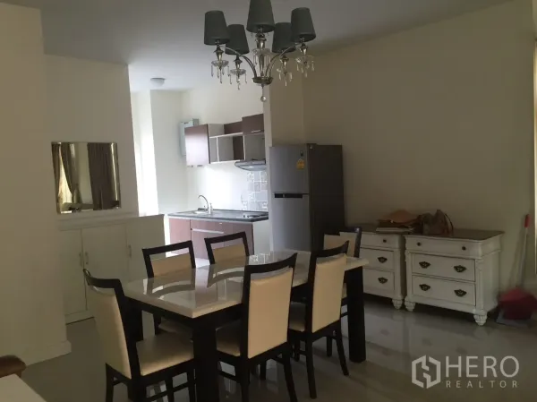 联排别墅 出租在Watthana, Bangkok - 餐厅与开放式小厨房，六人餐桌、吊灯与冰箱一体。