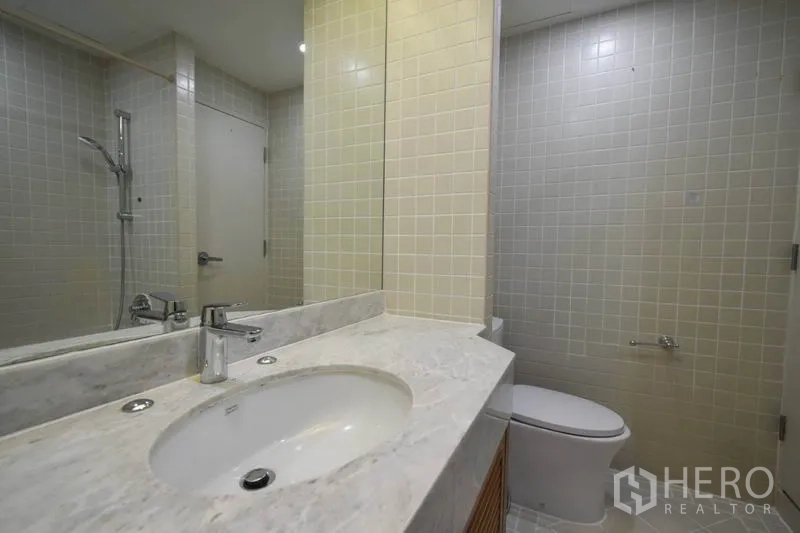 คอนโด ให้เช่าในPathum Wan, Bangkok - ห้องน้ำแขก ผนังกระเบื้อง เคาน์เตอร์อ่างล้างหน้า และพื้นที่อาบน้ำ