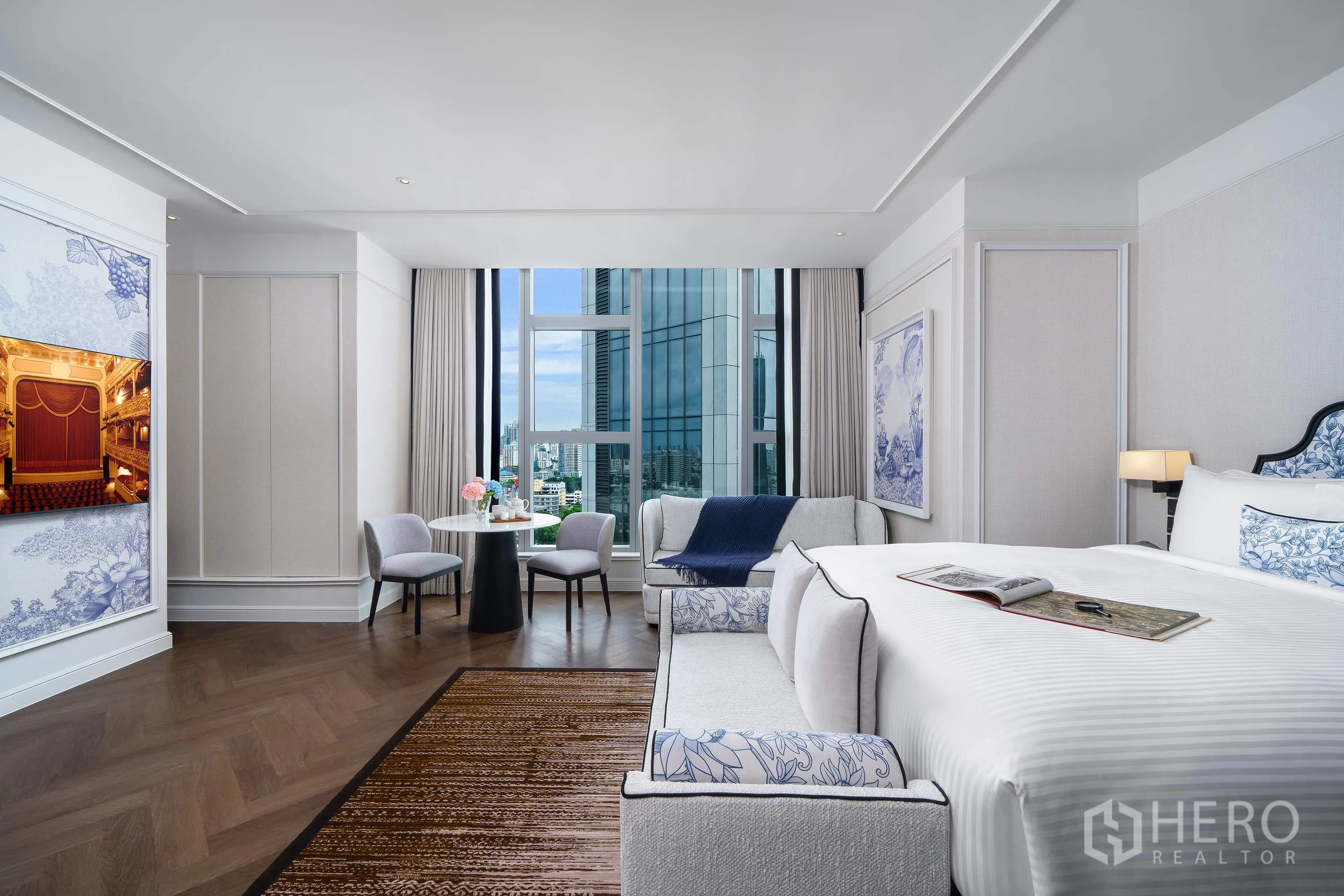 Condominium for rent in Khlong Toei, Bangkok - Bedroom with seating area and dining table beside large windows overlooking the Bangkok skyline.