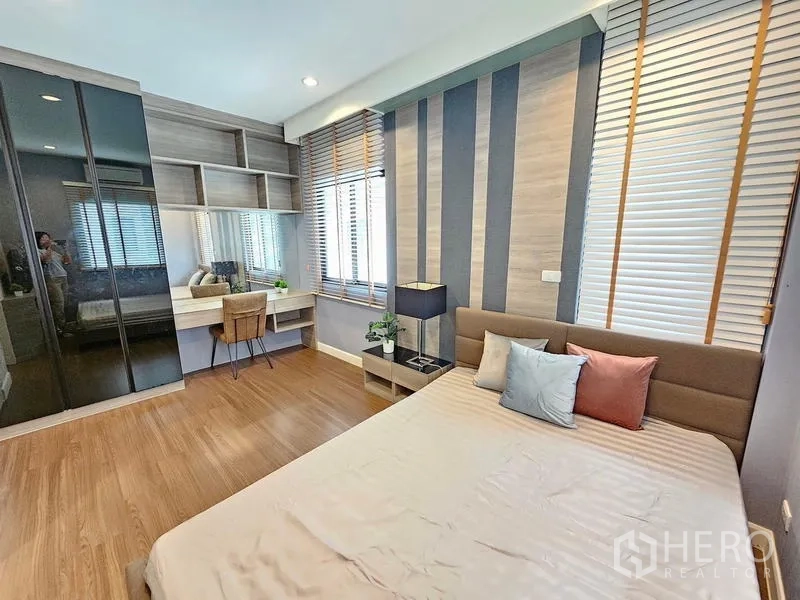Detached House for rent in Prawet, Bangkok - Bright bedroom with striped feature wall, built-in desk, and glossy wardrobe.