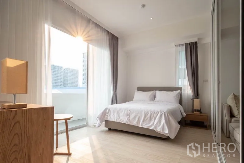 คอนโด ให้เช่าในKhlong Toei, Bangkok - ห้องนอนรับแสงธรรมชาติ เตียงคู่ ผ้าม่านโปร่ง และประตูออกสู่ระเบียง