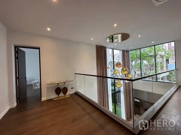 独立式住宅 出租 - 二层走廊，玻璃栏杆与装饰吊灯，旁有高窗