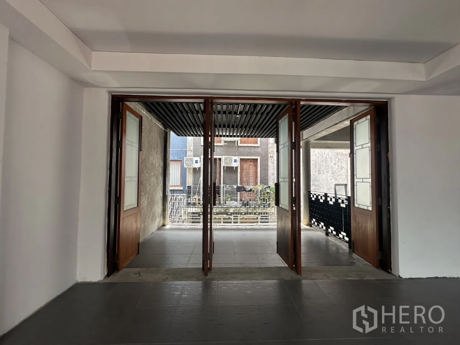 สำนักงานที่บ้าน ให้เช่าในPathum Wan, Bangkok - มุมมองจากภายในผ่านประตูไม้กระจกบานพับสู่โถงกึ่งเอาต์ดอร์