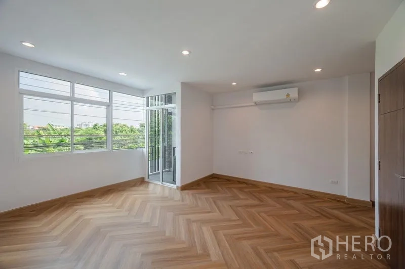 ทาวน์เฮาส์ ขายในLat Phrao, Bangkok - ห้องนอนกว้าง หน้าต่างหลายบาน แอร์ และทางออกสู่ระเบียง