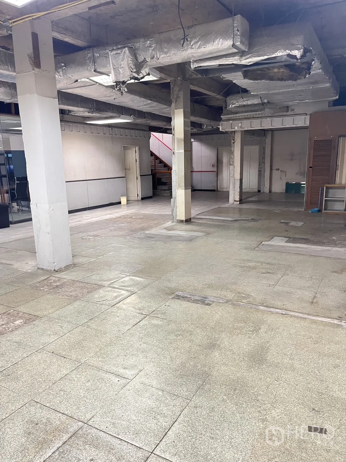 Warehouse for rent in Huai Khwang, Bangkok - Open-plan storage area featuring exposed ducting, pillars and durable flooring.